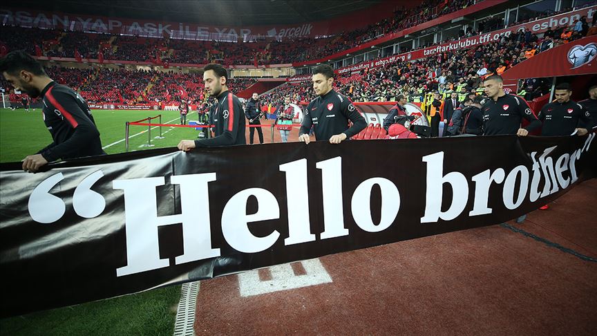 A Milli Futbol Takımı ısınmaya  Hello brother  yazılı pankartla çıktı